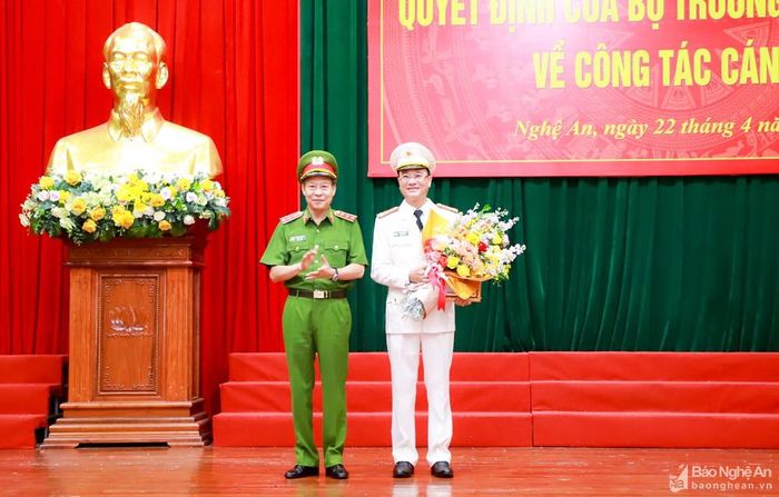 Thứ trưởng Bộ Công an Lê Quý Vương trao Quyết định và tặng hoa chúc mừng Đại tá Phạm Thế Tùng. Ảnh: Thành Duy