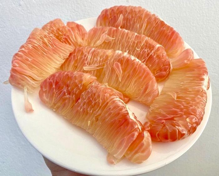 Giống bưởi da xanh có nguồn gốc ở xã Thanh Tân, huyện Mỏ Cày Bắc, tỉnh Bến Tre. Loại quả này được nhiều người ưa chuộng bởi vị thanh ngọt, không chua, không hạt, nước vừa phải, múi màu hồng, dễ lột... Ảnh: Trang.inr.