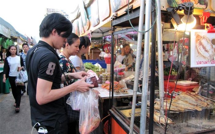 Người dân ghé qua chợ mua đồ ăn sau giờ làm việc.