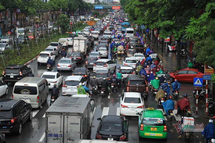 Trên đường Nguyễn Chí Thanh, các phương tiện chen nhau dưới cơn mưa như trút nước.