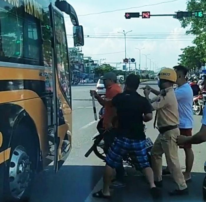 Người dân phối hợp với CSGT khống chế Lê Tuấn Hiệp (áo đỏ). 