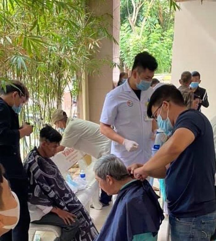Thành viên nhóm thiện nguyện cắt tóc cho bệnh nhân