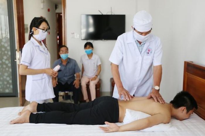 Lương y Lê Duy Năm đang điều trị cho bệnh nhân. Ảnh: ND.