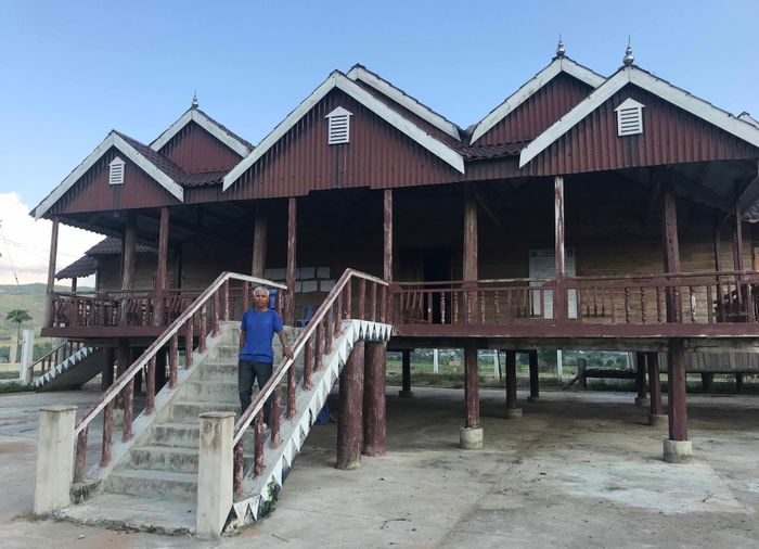 Ông Đinh Yen-Bí thư Chi bộ làng Jun bên nhà sinh hoạt cộng đồng khang trang của làng. Ảnh: Nguyễn Hồng