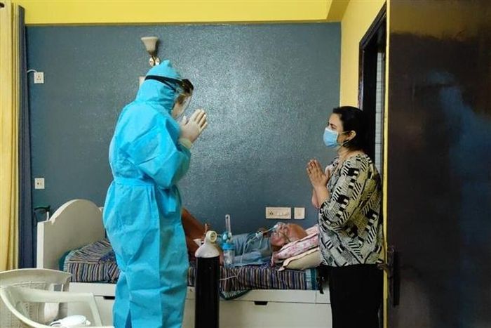 Một tình nguyện viên đang dạy người xin hỗ trợ cách sử dụng bình oxy. (Ảnh: Srinivas BV)