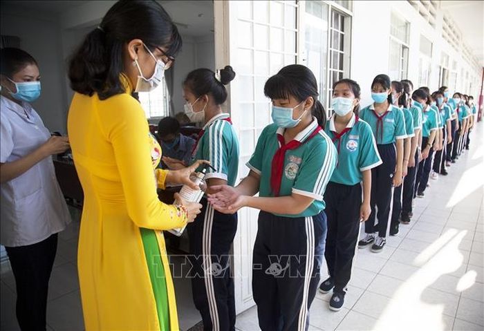 Các em Trường Trung học phổ thông Võ Văn Kiệt (Kiên Giang) thực hiện nghiêm túc công tác phòng, chống dịch COVID-19, rửa tay sát khuẩn trước khi vào lớp. Ảnh (tư liệu): Hồng Đạt/TTXVN