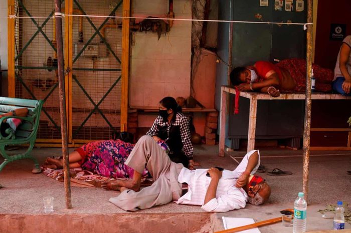  Bệnh nhân buộc phải nằm ra nền đất vì không còn giường. Ảnh: Reuters. 