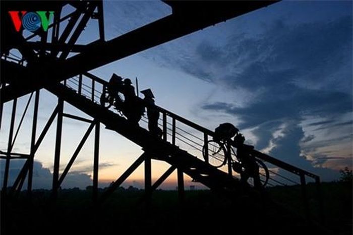 Những người nông dân từ bãi lên cầu trở về sau một ngày lao động. 