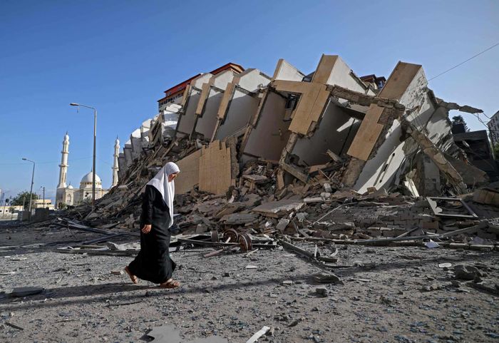  Một phụ nữ Palestinie bước đi qua tòa nhà bị phá hủy ở thành phố Gaza. Ảnh: Getty. 