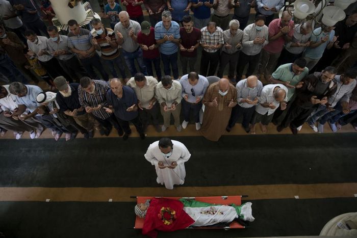  Người dân Palestine cầu nguyện bên thi thể của Rasheed Abu Arra - người đã thiệt mạng trong cuộc đụng độ với lực lượng Israel trong ngày 12/5. Theo số liệu từ AP, tính đến sáng 13/5, số người Palestine thiệt mạng trong cuộc giao tranh đã tăng lên 67 người, bao gồm 16 trẻ em và 5 phụ nữ. Ảnh: AP. 