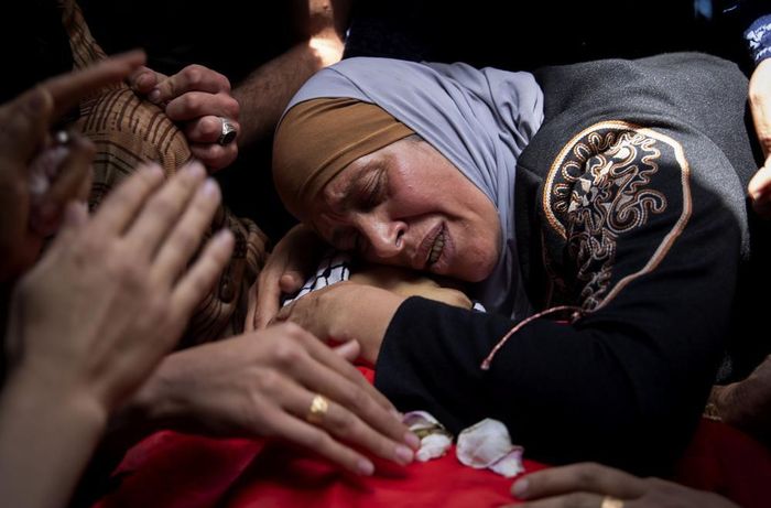  Một phụ nữ Palestine than khóc bên thi thể con trai Rasheed Abu Arra - người đã thiệt mạng trong cuộc đụng độ với lực lượng Israel ngày 12/5. Ảnh: AP. 