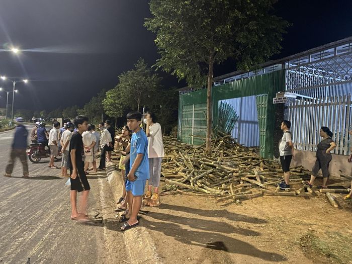 Củi từ xe tải mất phanh văng khắp đường, làm hỏng cửa cuốn nhà dân bên đường.