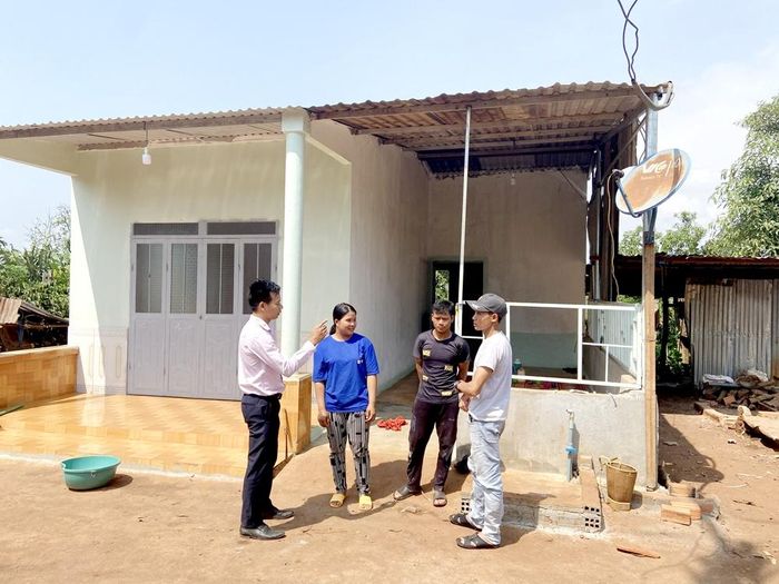 Anh Rơ Lan Hnhơn (ngoài cùng bên phải) cùng cán bộ Ngân hàng Chính sách xã hội thăm hỏi hộ vay vốn