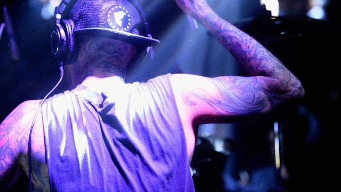Sau tai nạn máy bay, Travis Barker dùng vùng da ở lưng để ghép da tránh sẹo ở đùi, chân. Anh cho biết điều đó khiến vùng lưng của anh không đều màu. Anh quyết định xăm ảnh gia đình gồm cha mẹ và hai con để che khuyết điểm. "Tôi không xấu hổ về vết bỏng, tôi chỉ xem nó là hình xăm lớn, một phần của cuộc đời. Tôi xăm lên để nhớ về gia đình", nghệ sĩ Mỹ nói với GQ. Hình xăm ở lưng của Barker tốn khoảng 40-50 giờ để hoàn thành. Mỗi ngày, hai nghệ sĩ Franco Vescovi và Chuey Quintanar mất 10 giờ để xăm cho Barker. Ảnh: Getty.