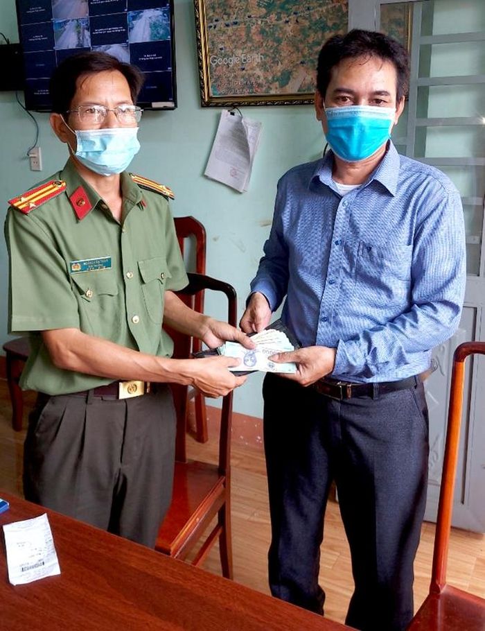 Trưởng Công an xã Đồng Tiến trao trả chiếc ví cùng số tài sản và giấy tờ cho anh Khang. 