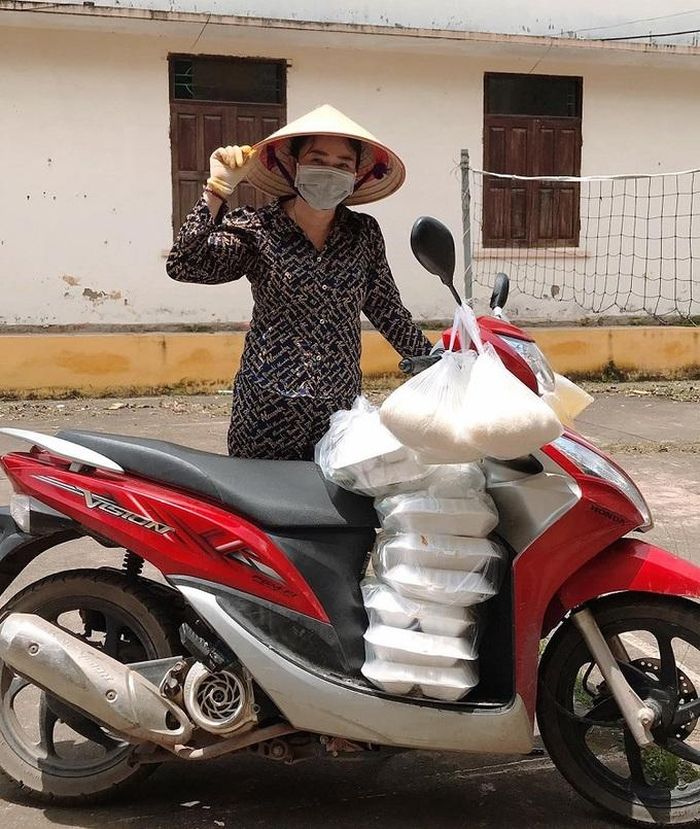Chị Nguyễn Thị Tình đội nắng đi phát cơm miễn phí cho cán bộ chốt kiểm dịch. Ảnh: Ngọc Nhi.