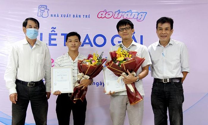 Nhà thơ Hồ Thi Ca (mép trái hình) và nhà thơ Lê Minh Quốc (mép phải hình) trao giải Khuyến khích cho hai tác giả Lê Hòa và Khét (thứ hai, từ trái qua)