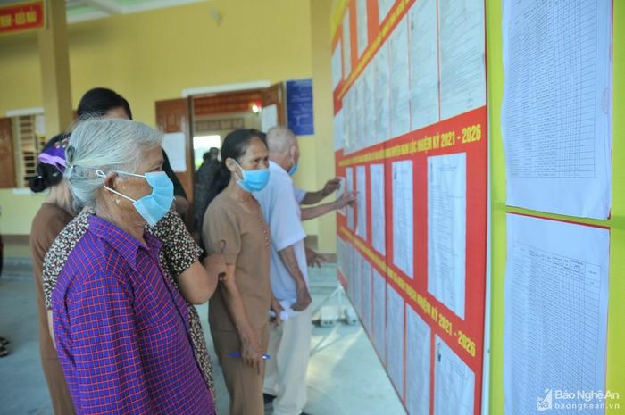 Người dân nghiên cứu danh sách các đại biểu ứng cử để chọn ra những người ưu tú nhất. Ảnh: Tiến Đông