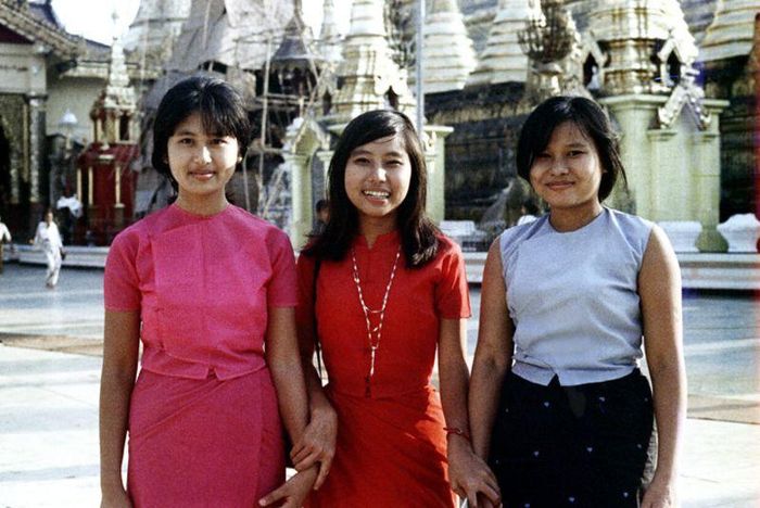 Ba cô gái Myanmar tạo dáng chụp hình trước những tòa tháp dát vàng.