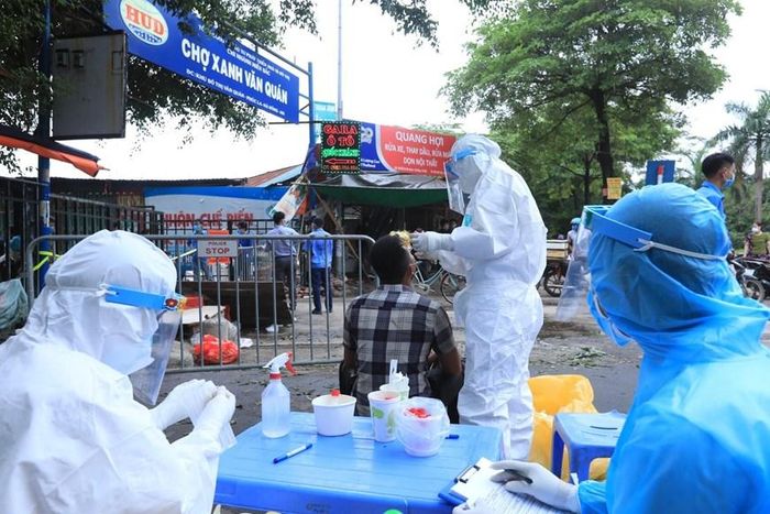 Lấy mẫu xét nghiệm SARS-CoV-2 các tiểu thương bán hàng trong chợ Xanh Văn Quán, (Hà Nội) nơi ca bệnh COVID-19 từng đến mua sắm. (Ảnh: TTXVN)