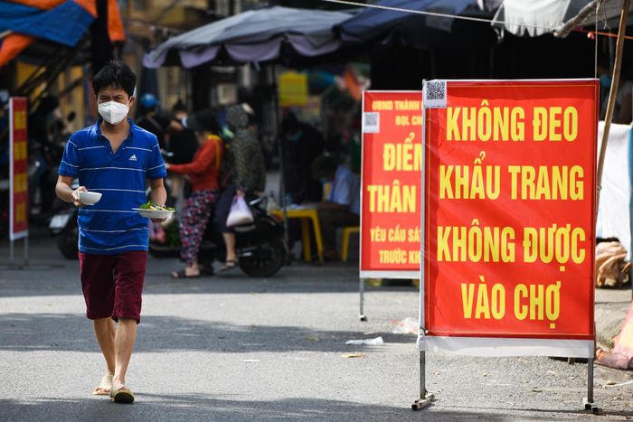 Hàng loạt tấm biển lớn với nội dung yêu cầu người dân đeo khẩu trang được đặt dọc lối đi bên ngoài chợ Nhớn.
