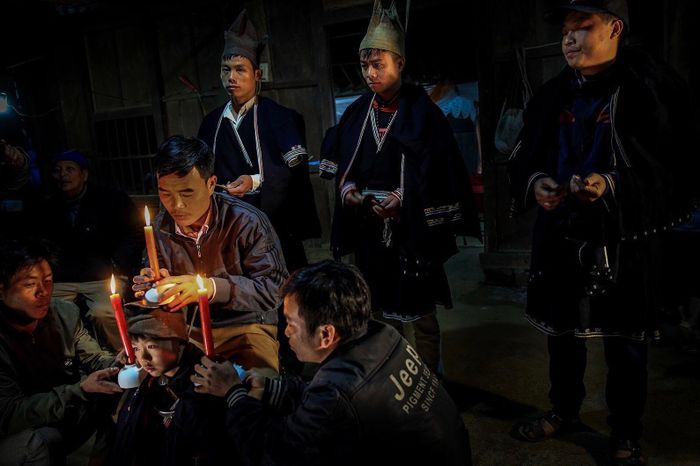 Thầy mo đốt 3 cây nến, đặt lên hai vai và trên đầu của trẻ rồi cúng mời tổ tiên về chứng giám. 