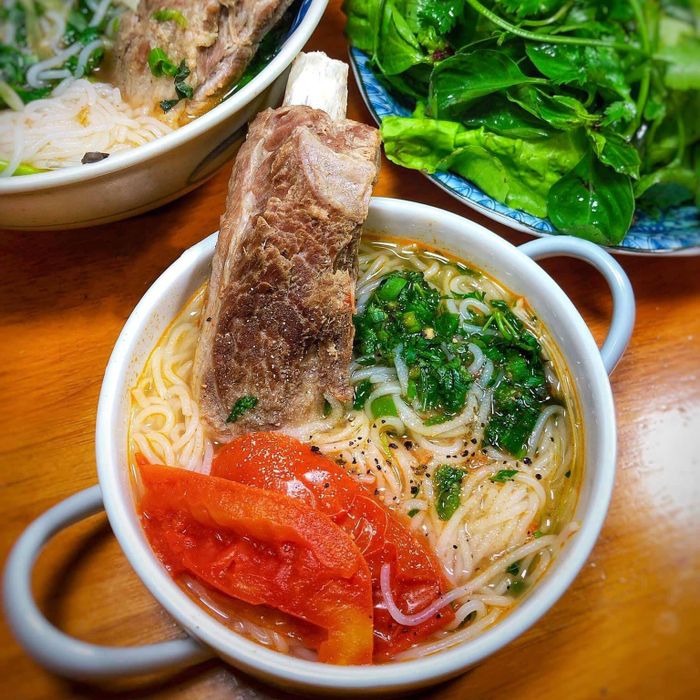 Một món bún hấp dẫn khác cho bữa sáng dinh dưỡng trong mùa dịch là bún sườn cây. Tôi thường hầm cả cây sườn, độ mềm vừa phải. Để tiết kiệm thời gian, bạn nên hầm sườn từ tối. Buổi sáng, bạn cần chuẩn bị cà chua thả nồi nước ninh sườn, nấu mềm và nêm gia vị vừa ăn. Cà chua chín, bạn xếp bún, sườn cây, thêm hành lá, chan nước dùng và thưởng thức.