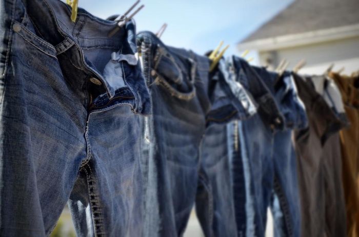 Bạn nên phơi quần jeans bằng kẹp để giữ phom dáng của quần. Ảnh: Sourcing Journal.