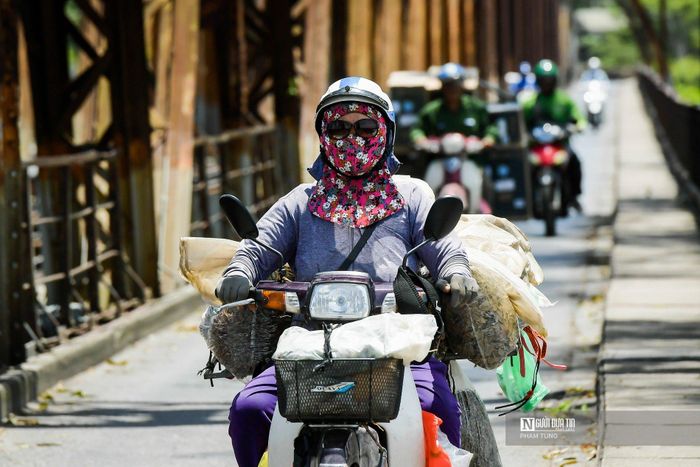 Phần lớn người đi đường đều mặc áo chống nắng, đi găng tay, đeo kính... để che chắn cái nắng cháy da cháy thịt