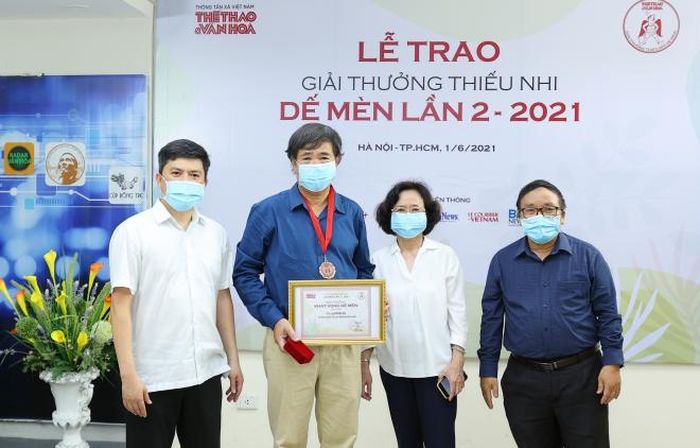 Nhà báo Lê Xuân Thành, Tổng biên tập báo TT&VH, Trưởng BTC giải (ngoài cùng bên trái) và nhà thơ Trần Đăng Khoa, Chủ tịch Hội đồng giám khảo (phải) chụp ảnh lưu niệm cùng nhà văn Bình Ca và vợ tại Lễ trao giải Dế Mèn