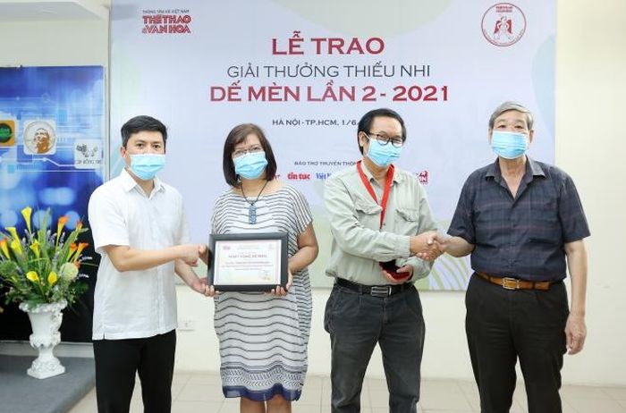 Nhà báo Lê Xuân Thành, Tổng biên tập báo TT&VH, Trưởng BTC giải (ngoài cùng bên trái) và nhạc sĩ - giám khảo Nguyễn Thụy Kha (ngoài cùng bên phải) trao giải Khát vọng Dế Mèn cho nữ NSND Phương Hoa và đồng tác giả kịch bản “Khúc gỗ mục” Phan Đức Tuấn. Ảnh: Hòa Nguyễn