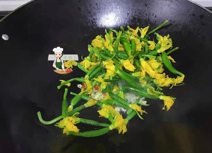 Cho hoa dưa chuột vào xào không thêm nước, đảo liên tục cho đến khi chín tới, cuối cùng nêm chút muối vừa miệng, rưới chút tinh chất gà cho thêm vị, xào đều tay.