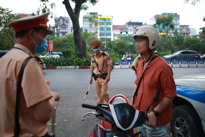 Tại khu vực đường Láng (quận Cầu Giấy, Hà Nội), Đội CSGT số 3 yêu cầu dừng xe đối với những người tham gia giao thông không đeo khẩu trang khi lưu thông trên tuyến đường này. 