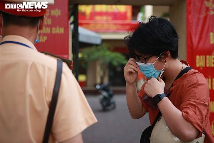 Trước khi kiểm tra hành chính và thông báo mức xử phạt, cán bộ chiến sĩ phát khẩu trang cho người vi phạm để đảm bảo an toàn trong khi làm việc.