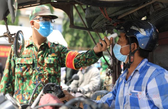 Người đi đường được đo thân nhiệt khi đi qua Đồng Nai