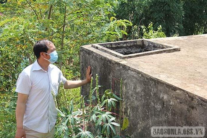Ông Hoàng Văn Bun, Trưởng bản Huổi Ná, xã Chiềng Ơn bên bể điều tiết nước sinh hoạt bị bỏ hoang.
