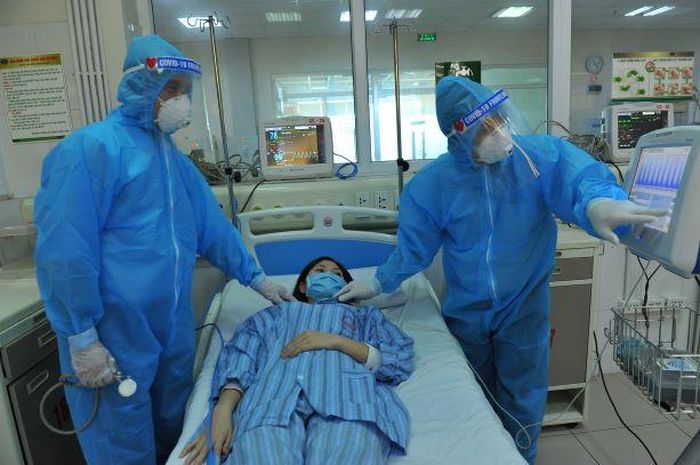 TS.BS. Thân Mạnh Hùng (trái ảnh) trao đổi với đồng nghiệp về một trường hợp bệnh nhân COVID-19. Ảnh: Nguyễn Á.