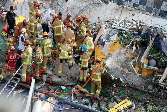 Các nhân viên cứu hộ đang tiến hành giải cứu người mắc kẹt. Ảnh: AP