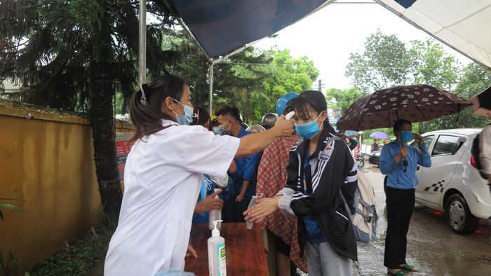 Ngay từ sáng sớm ngày thi đầu tiên, lực lượng y tế đã túc trực đo thân nhiệt, sát khuẩn tay và phát khẩu trang miễn phí cho thí sinh ở điểm thi Trường THPT Chân Mộng
