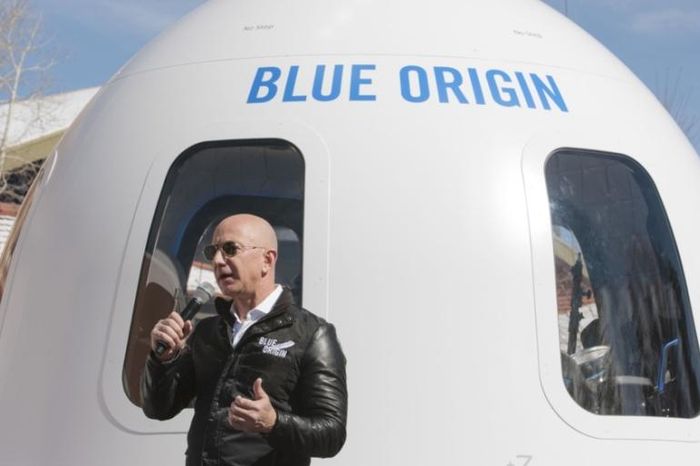  Tỷ phú Jeff Bezos đứng bên cạnh một phi thuyền của Blue Origin. Ảnh: Al Jazeera. 