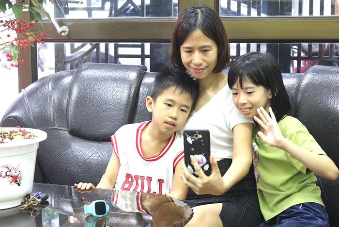 Minh Anh cùng mẹ và em trai nói chuyện với bố qua video trong thời gian bố được nghỉ giải lao.
