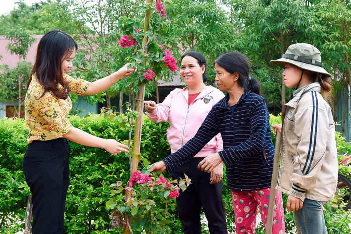 Cán bộ, công chức xã Đak Ta Ley tuyên truyền người dân trồng hoa trong sân nhà để tạo cảnh quan môi trường xanh-sạch-đẹp.