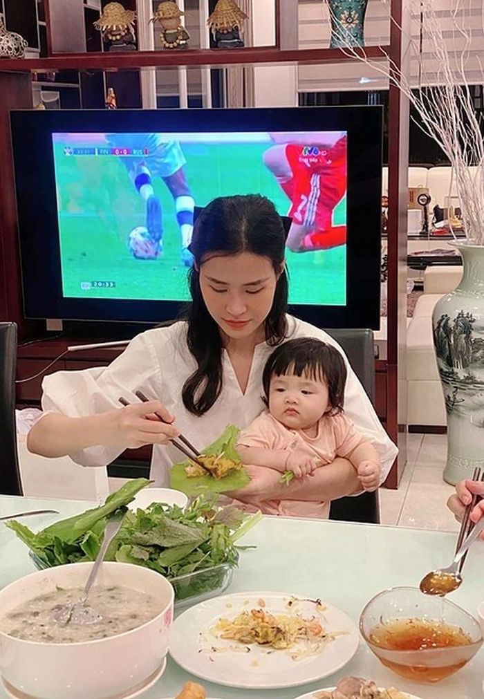 Con gái Đông Nhi chăm chú nhìn mẹ cuốn bánh xèo. 