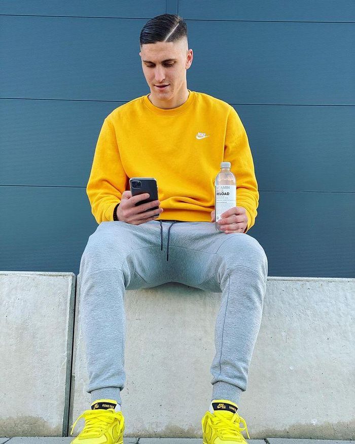 Roland Sallai phối áo sweater kèm giày sneakers màu vàng neon nổi bật. Anh chọn quần jogger thun nhằm mang đến sự thoải mái cho bộ trang phục street style.