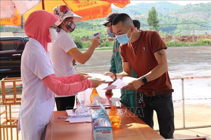 Lực lượng y tế tỉnh Kon Tum tiến hành đo thân nhiệt và hướng dẫn cho người dân khai báo y tế. Ảnh: TTXVN phát