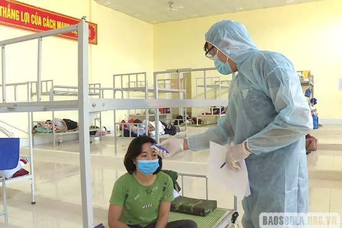 Kiểm tra thân nhiệt cho người trong khu cách ly y tế tập trung tại Trung tâm Bồi dưỡng Chính trị huyện Mộc Châu.