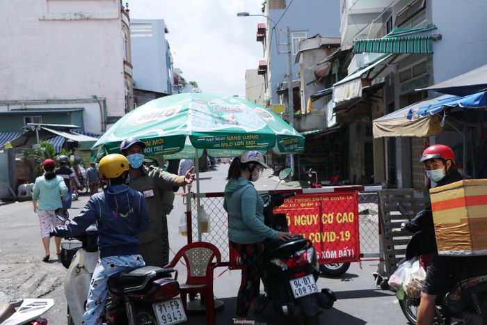 Chính quyền phường 10, quận 11, TPHCM lập chốt kiểm soát phía trước chợ. Người dân có thẻ sẽ được chạy xe máy vào trong. Người chưa có thẻ được yêu cầu gửi xe máy ở ngoài và đi bộ vào đăng ký cấp thẻ.