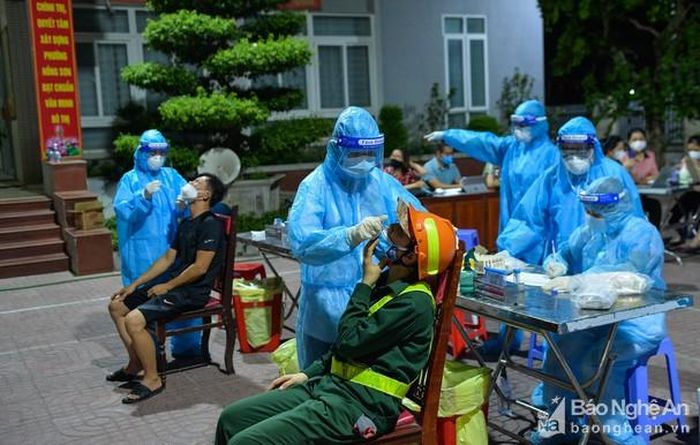 Lấy mẫu xét nghiệm những người liên quan đến chợ đầu mối ở thành phố Vinh. Ảnh: Thành Cường
