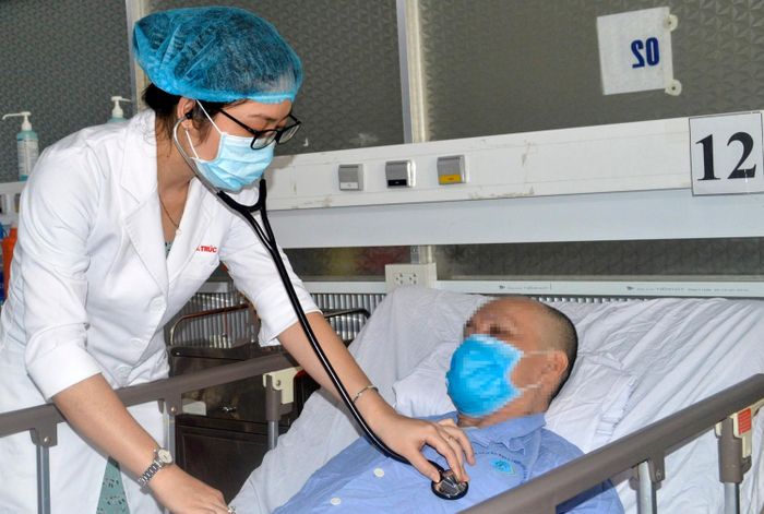 Bác sĩ thăm khám cho ông N.V.H. trước khi bệnh nhân ra viện. Ảnh: T.P.