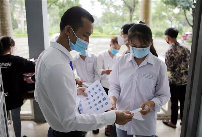 Cán bộ coi thi gọi thí sinh vào phòng thi tại điểm thi Trường Trung học Phổ thông huyện Than Uyên (Lai Châu). Ảnh: Quý Trung - TTXVN